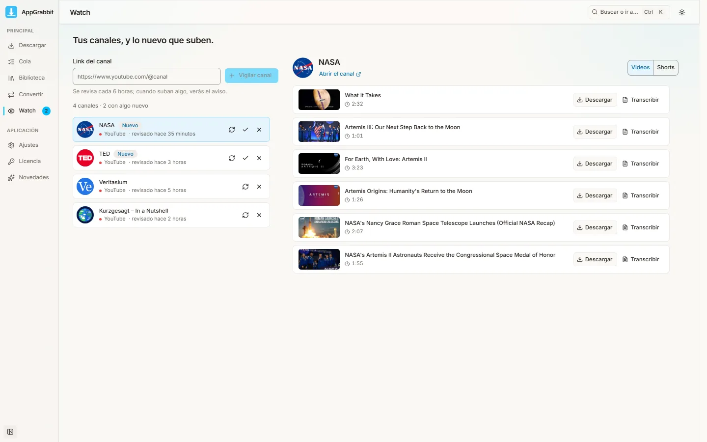 La sección Watch de AppGrabbit: la lista de canales con la marca Nuevo y los últimos videos del canal elegido con los botones Descargar y Transcribir.